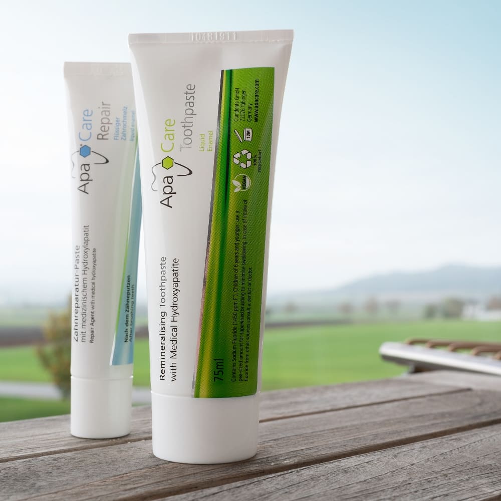 ApaCare Repair und ApaCare Remineralisierende Zahncreme auf Holz Untergrund vor Natur